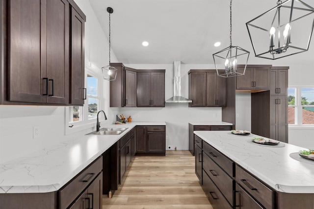 3453 Veanna Blvd, Oshkosh, WI 54904 - kitchen with wall chimney range hood, a chandelier, light wood-style flooring, dark brown cabinets, and recessed lighting