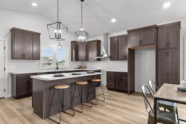3453 Veanna Blvd, Oshkosh, WI 54904 - kitchen with wall chimney exhaust hood, dark brown cabinets, lofted ceiling, a kitchen island, and a kitchen breakfast bar