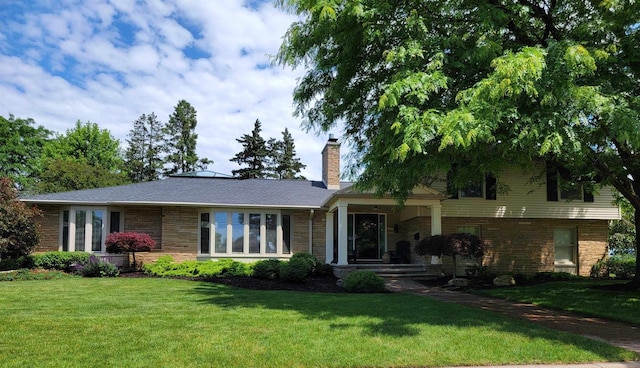 1824 W Reid Dr, Appleton, WI 54914 - view of front of home with a front yard, stone siding, and a chimney