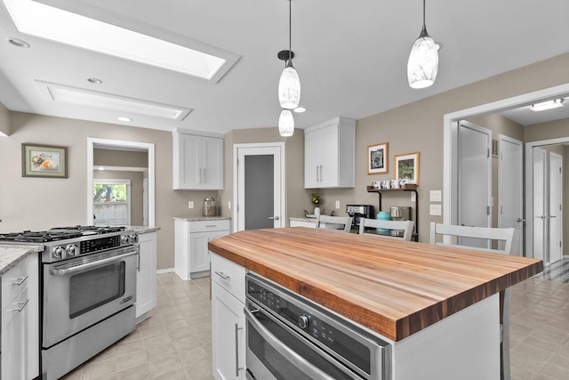 1824 W Reid Dr, Appleton, WI 54914 - kitchen with stainless steel range with gas cooktop, butcher block counters, light flooring, white cabinets, and pendant lighting