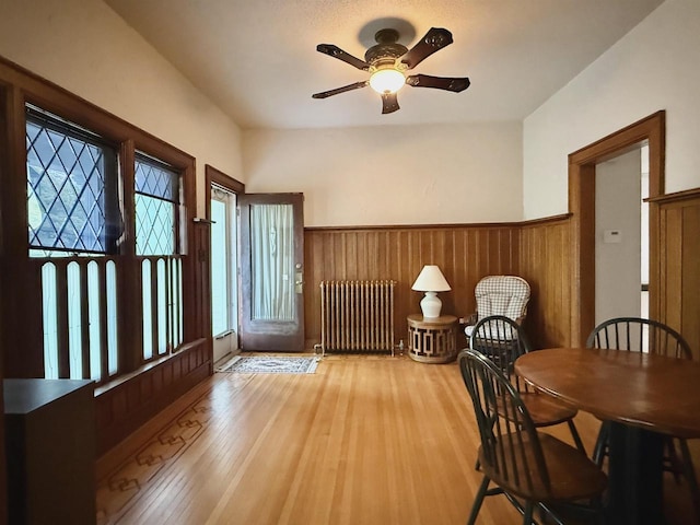 195 E Park Ave, Berlin, WI 54923 - dining area with radiator, plenty of natural light, ceiling fan, a wainscoted wall, and wood finished floors