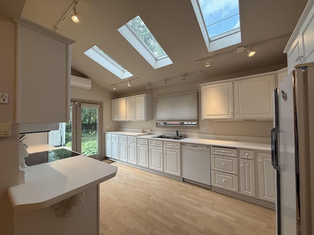 195 E Park Ave, Berlin, WI 54923 - kitchen featuring rail lighting, white appliances, a skylight, an AC wall unit, and lofted ceiling