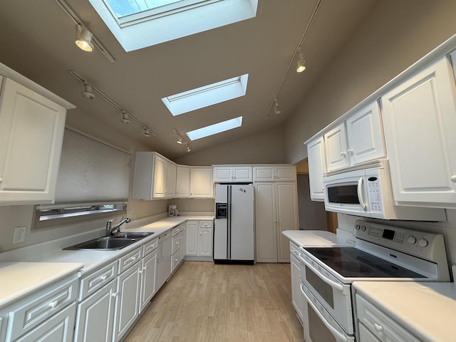 195 E Park Ave, Berlin, WI 54923 - kitchen featuring white appliances, a skylight, rail lighting, light wood finished floors, and lofted ceiling