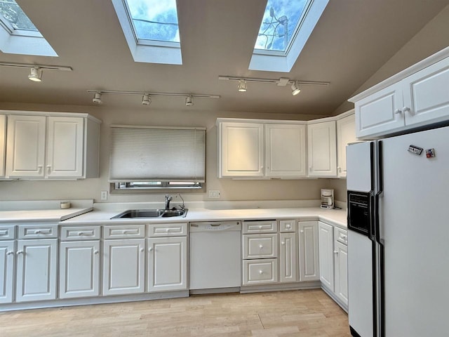 195 E Park Ave, Berlin, WI 54923 - kitchen featuring a skylight, white appliances, rail lighting, white cabinets, and lofted ceiling