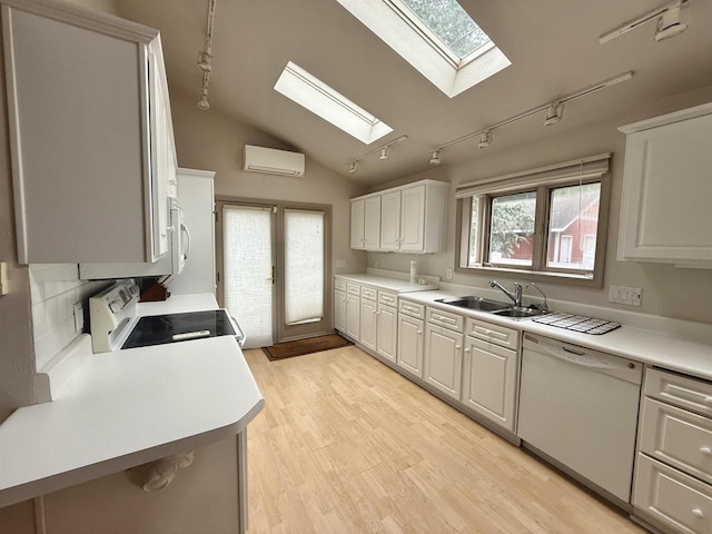 195 E Park Ave, Berlin, WI 54923 - kitchen featuring white appliances, track lighting, a skylight, a wall mounted air conditioner, and vaulted ceiling