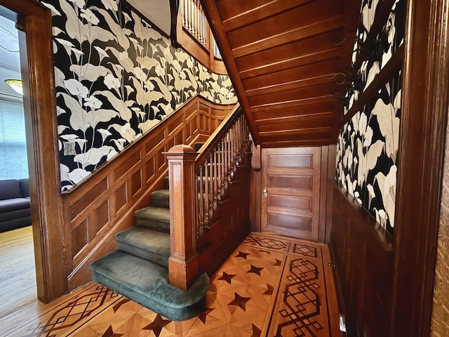 195 E Park Ave, Berlin, WI 54923 - staircase featuring wallpapered walls, vaulted ceiling, and wainscoting