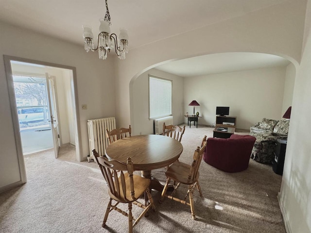 195 E Park Ave, Berlin, WI 54923 - dining room featuring arched walkways, radiator, carpet floors, and a chandelier