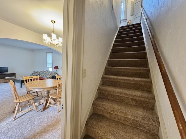 195 E Park Ave, Berlin, WI 54923 - stairs with carpet floors, arched walkways, a textured wall, and a chandelier