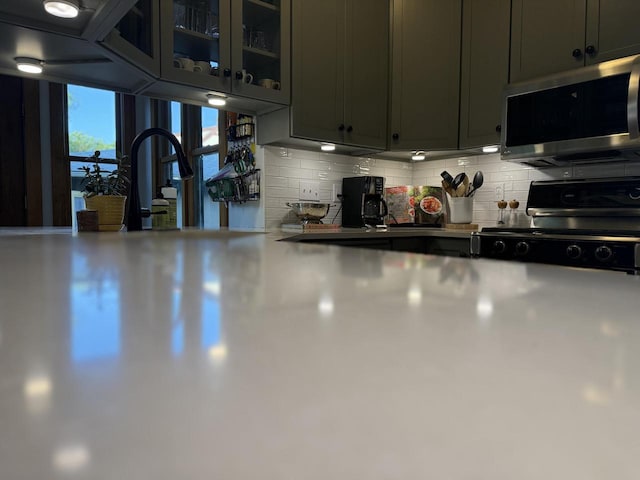 2505 Robinsdale Ave, La Crosse, WI 54601 - kitchen featuring stainless steel appliances, tasteful backsplash, and glass insert cabinets
