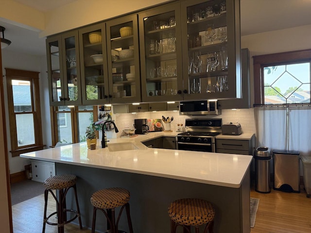2505 Robinsdale Ave, La Crosse, WI 54601 - kitchen with stainless steel appliances, light countertops, a breakfast bar area, and tasteful backsplash