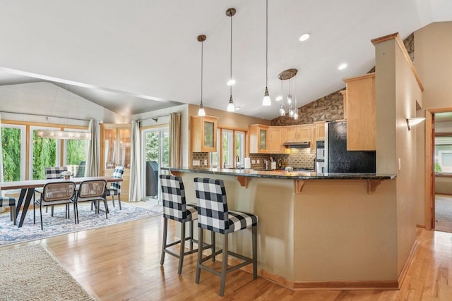 3426 W Links Dr, Franklin, WI 53132 - kitchen with vaulted ceiling, freestanding refrigerator, light wood-style flooring, glass insert cabinets, and decorative backsplash