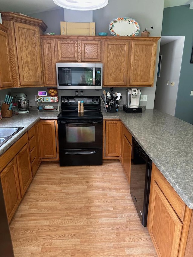 W6767 Pine Ave, Medford, WI 54451 - kitchen with black appliances, light wood-style floors, and brown cabinetry