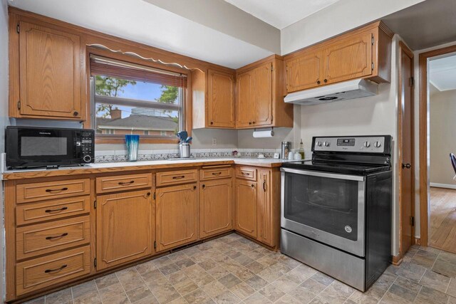 613 Pleasant View St, Wauwatosa, WI 53226 - kitchen featuring stainless steel electric stove, under cabinet range hood, black microwave, stone finish flooring, and light countertops