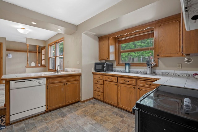 613 Pleasant View St, Wauwatosa, WI 53226 - kitchen with black appliances, a peninsula, tile counters, brown cabinets, and recessed lighting