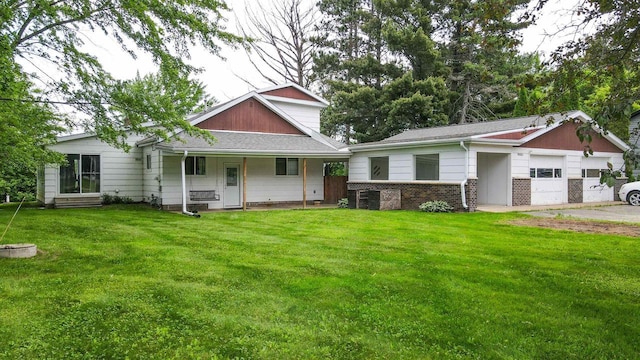W4976 Pinewood Ln, Merrill, WI 54452 - view of front facade featuring a front lawn, a garage, a porch, and brick siding
