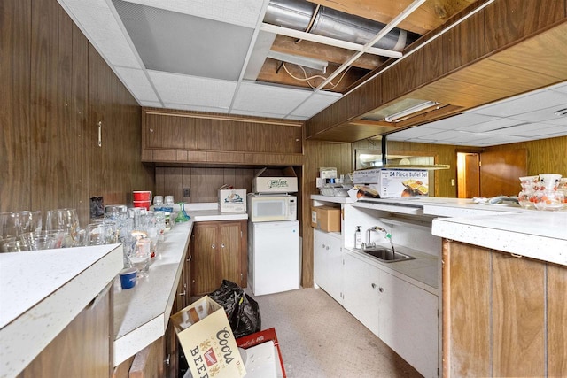 W4976 Pinewood Ln, Merrill, WI 54452 - finished basement with wooden walls, fridge, and a drop ceiling