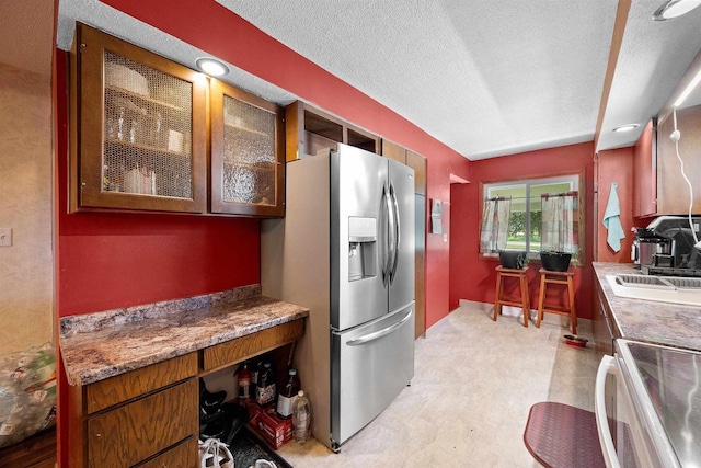 W4976 Pinewood Ln, Merrill, WI 54452 - kitchen with stainless steel refrigerator with ice dispenser, electric stove, a textured ceiling, and glass insert cabinets