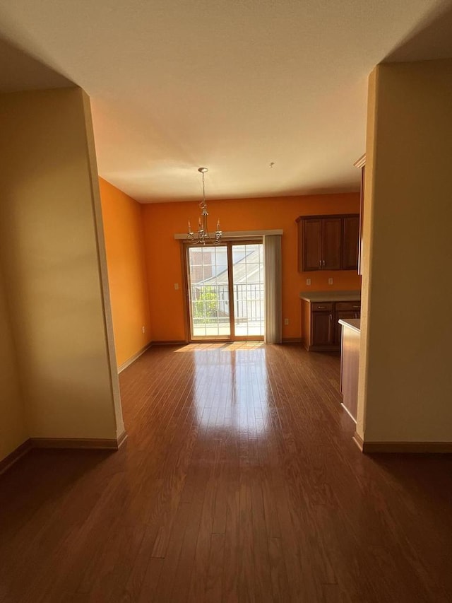7918 Fredricksburg Ct Unit 101, Bristol, WI 53104 - unfurnished living room with a chandelier and dark wood-style flooring
