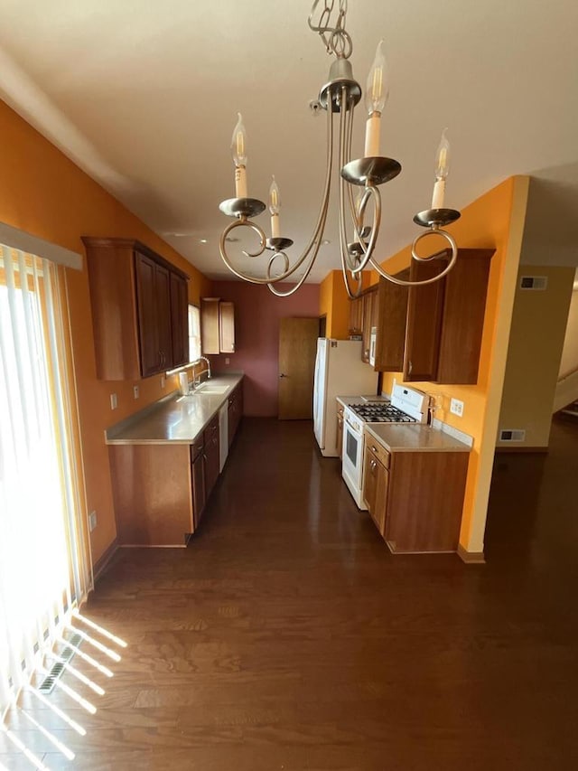 7918 Fredricksburg Ct Unit 101, Bristol, WI 53104 - kitchen featuring white appliances, a chandelier, dark wood-type flooring, light countertops, and brown cabinetry