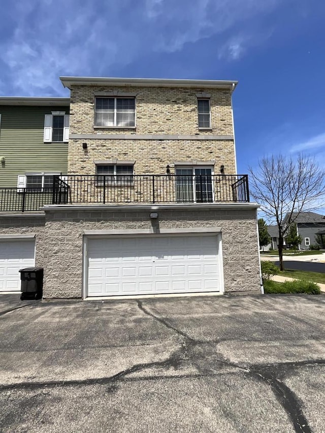 7918 Fredricksburg Ct Unit 101, Bristol, WI 53104 - rear view of property featuring a garage, a balcony, and driveway
