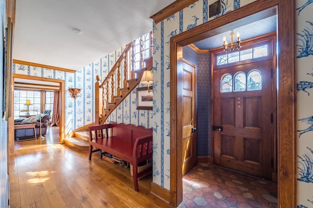 918 Fulton St, Wausau, WI 54403 - entryway featuring wallpapered walls, a chandelier, stairs, crown molding, and hardwood / wood-style flooring