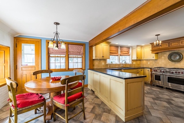 918 Fulton St, Wausau, WI 54403 - kitchen with double oven range, dark countertops, a peninsula, backsplash, and plenty of natural light