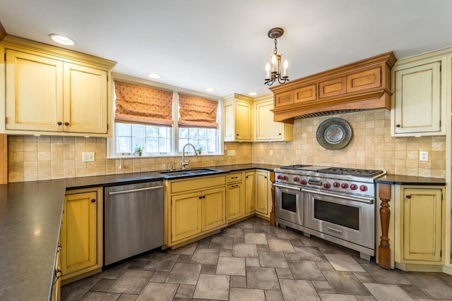 918 Fulton St, Wausau, WI 54403 - kitchen featuring appliances with stainless steel finishes, dark countertops, cream cabinets, a chandelier, and decorative light fixtures