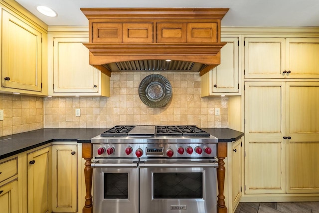 918 Fulton St, Wausau, WI 54403 - kitchen featuring range with two ovens, custom range hood, cream cabinets, and dark countertops