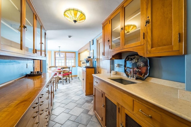 918 Fulton St, Wausau, WI 54403 - kitchen featuring brown cabinets, glass insert cabinets, and pendant lighting