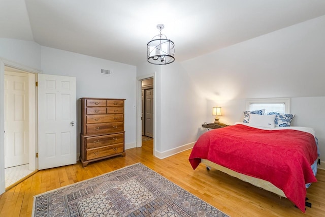 918 Fulton St, Wausau, WI 54403 - bedroom featuring wood finished floors, vaulted ceiling, and a chandelier
