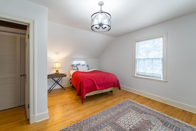 918 Fulton St, Wausau, WI 54403 - bedroom with light wood finished floors, vaulted ceiling, and a chandelier