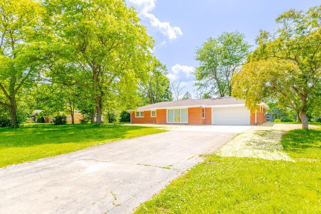 7309 S 46th St, Franklin, WI 53132 - view of front of house with a garage, asphalt driveway, a front yard, and brick siding