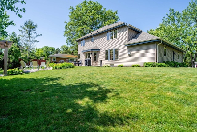 4474 N 107th St, Wauwatosa, WI 53225 - back of property featuring a lawn, a shingled roof, and a patio