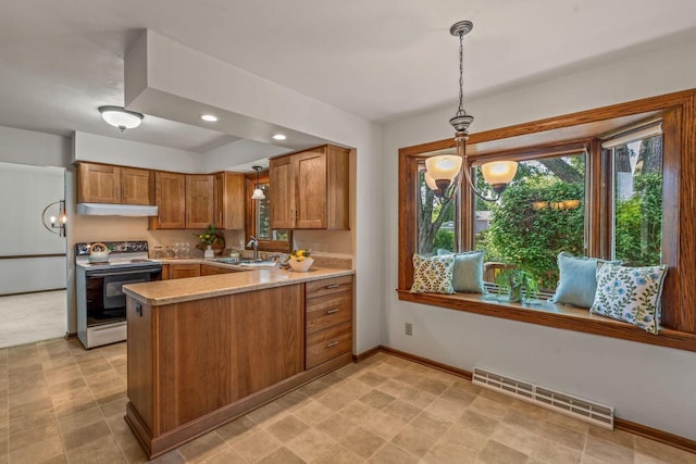 1512 David Ln, Waukesha, WI 53189 - kitchen with range with electric cooktop, under cabinet range hood, a peninsula, brown cabinets, and light countertops