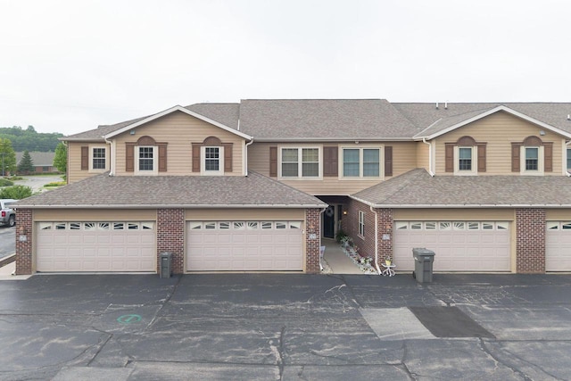W162S7013 Olive Cir, Muskego, WI 53150 - townhome / multi-family property featuring brick siding, driveway, an attached garage, and a shingled roof