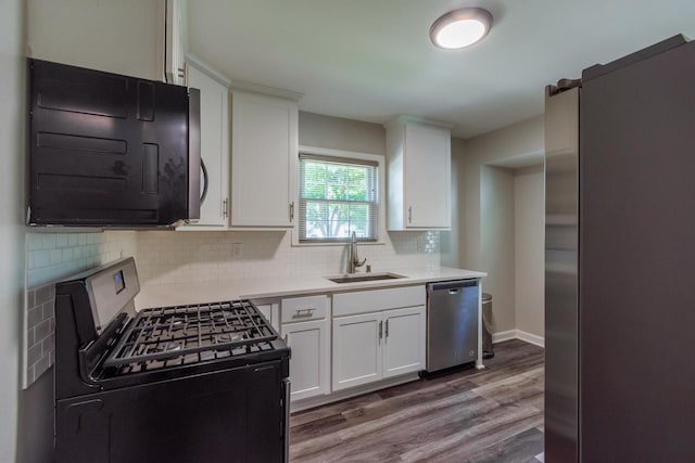 6421 W Girard Ave, Milwaukee, WI 53210 - kitchen featuring appliances with stainless steel finishes, wood finished floors, white cabinetry, backsplash, and light countertops
