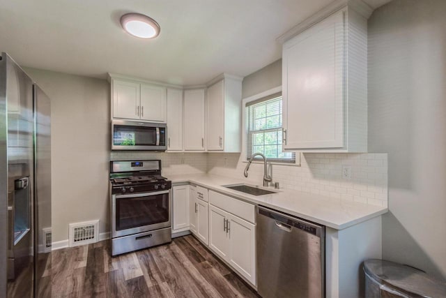 6421 W Girard Ave, Milwaukee, WI 53210 - kitchen featuring appliances with stainless steel finishes, dark wood-style flooring, white cabinets, and light countertops