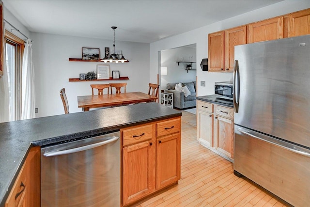 130 W Windsor Ave, Cottage Grove, WI 53527 - kitchen featuring appliances with stainless steel finishes, dark countertops, light wood-style floors, hanging light fixtures, and open shelves