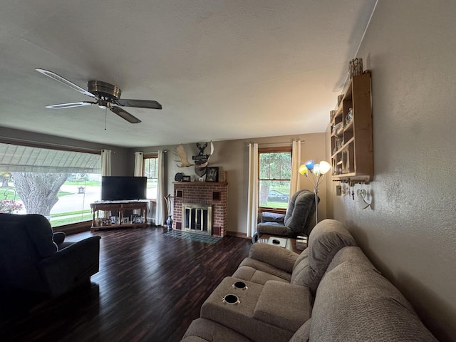 34 Elm Street N, St, La Crescent, MN 55947 - living room featuring dark wood-style floors, plenty of natural light, a ceiling fan, a brick fireplace, and a textured wall