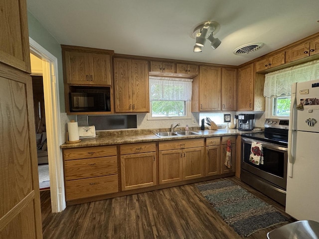 34 Elm Street N, St, La Crescent, MN 55947 - kitchen featuring electric stove, black microwave, freestanding refrigerator, brown cabinetry, and dark wood-style flooring