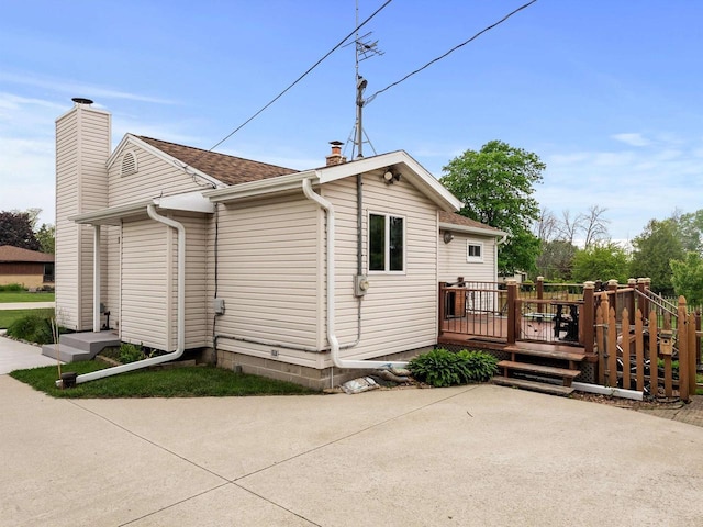 3715 N 17th St, Sheboygan, WI 53083 - rear view of house with a chimney, a deck, a patio, and roof with shingles