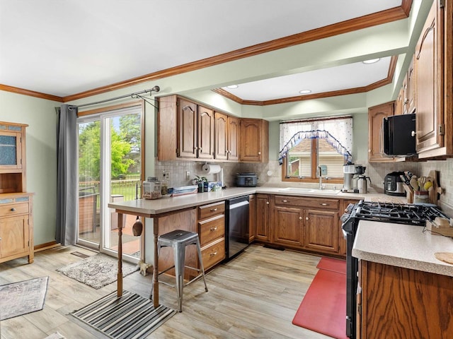 3715 N 17th St, Sheboygan, WI 53083 - kitchen with stainless steel appliances, light countertops, light wood-style floors, backsplash, and crown molding