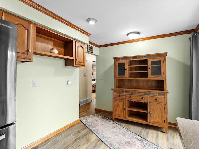 3715 N 17th St, Sheboygan, WI 53083 - kitchen featuring open shelves, freestanding refrigerator, ornamental molding, light wood-style flooring, and brown cabinets