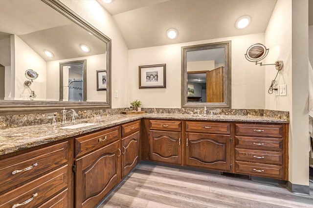 1450 Weber Ct, Hartland, WI 53029 - full bathroom with double vanity, vaulted ceiling, and wood finished floors