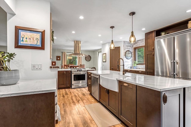 1450 Weber Ct, Hartland, WI 53029 - kitchen with high quality appliances, healthy amount of natural light, light wood-type flooring, recessed lighting, and a kitchen island with sink