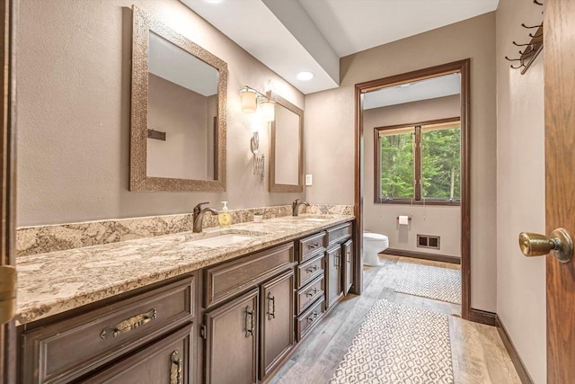 1450 Weber Ct, Hartland, WI 53029 - full bathroom with double vanity and wood finished floors