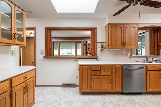 3720 Elm Dr, La Crosse, WI 54601 - kitchen featuring stainless steel dishwasher, a skylight, brown cabinetry, ceiling fan, and light countertops