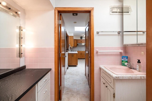 3720 Elm Dr, La Crosse, WI 54601 - bathroom featuring tile walls, vanity, a wainscoted wall, and tile patterned flooring