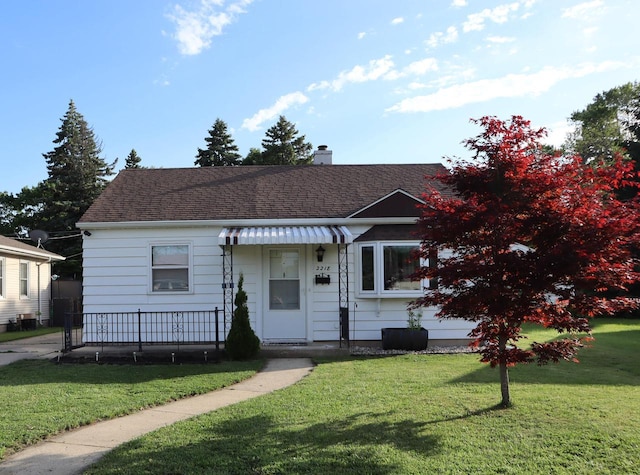 2218 Jerome Blvd, Racine, WI 53403 - view of front of property with a front lawn, a chimney, and roof with shingles