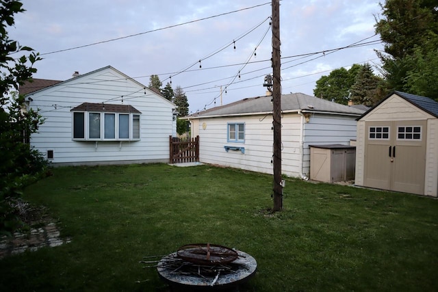 2218 Jerome Blvd, Racine, WI 53403 - view of grassy yard with a storage shed and a fire pit